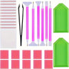 A collection of diamond painting accessories including applicators, pens, and green painting mats.