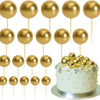 Eine Anordnung von zwanzig goldenen Ball-Kekstoppern auf Stäbchen in einer Reihe.