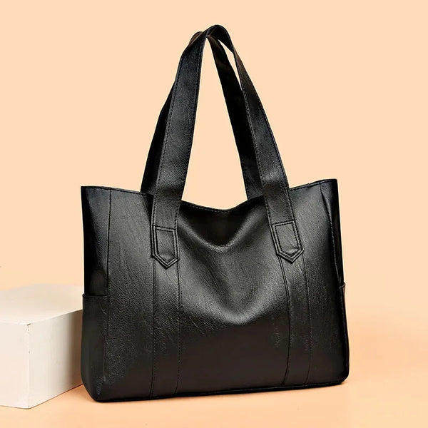 A black vintage canvas shoulder bag with handles is displayed on a light background.
