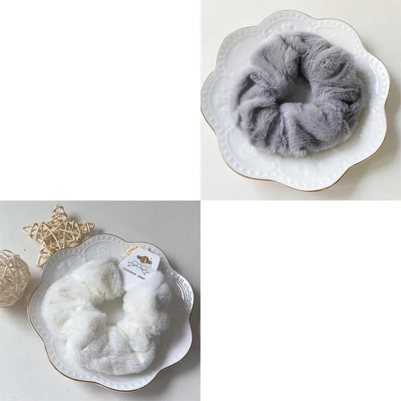 A close-up of a gray plush coil hair tie resting on a white ceramic plate.