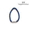 A close-up view of a sapphire blue rope tieback with a silver magnetic clasp.