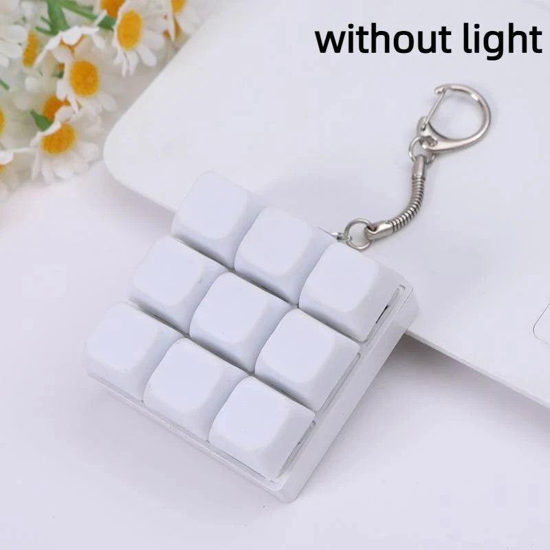 White mechanical keychain fidget toy with custom keycaps attached to a silver chain.