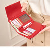 A red minimalist folding wallet shown being held by a hand, highlighting its RFID protection features.