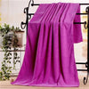 A vibrant magenta microfiber bath towel draped over a black metal rack.