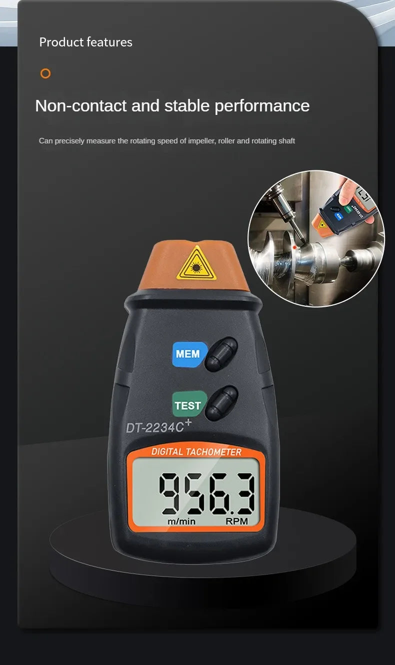 A black digital tachometer measuring 956.3 RPM, used for non-contact measurement of rotating shafts.
