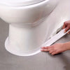 Eine Hand appliziert ein Stück weißes, selbstklebendes Silikondichtband am Sockel einer weißen Porzellan-Toilettenschüssel.