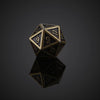 A bronze metal polyhedral dice set, likely a d10, resting on a reflective surface.