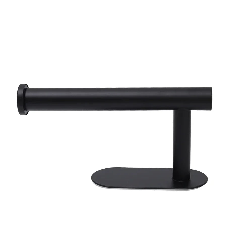 A black stainless steel self-adhesive toilet paper holder with a flat base.