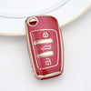 A close-up of a glossy red TPU key fob cover with silver embossed symbols for car keys.