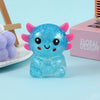 A bright blue squishy stress ball shaped like an axolotl with pink accents, resting on a light blue surface.