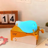 A glowing blue silicone duck night light rests on an orange box.