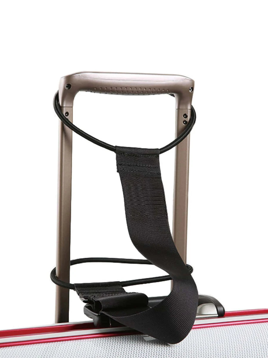 A black reusable elastic luggage strap is shown attached to a brown travel frame.