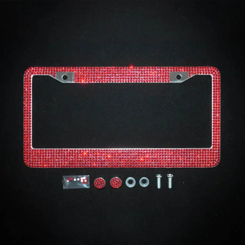 A rectangular license plate frame covered in red crystal rhinestones with mounting tabs and small accessories.
