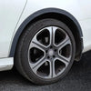 A close-up view of a white car wheel arch with a black trim and a silver alloy wheel.