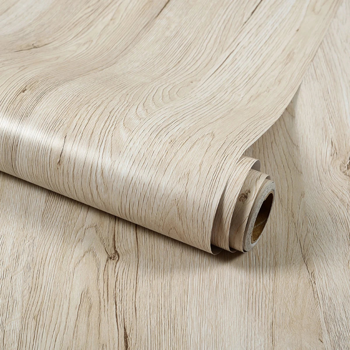 Roll of light beige wood grain wallpaper film showing the texture and rolled edge.