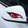 A close-up of a white car surface featuring a black and red cat eye decal design.
