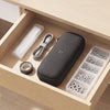 A gray electric screwdriver is shown in a wooden box with various bits and accessories.