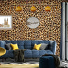 A living room featuring a blue sofa against a leopard print wall with framed artwork and modern decor.