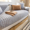 A light gray quilted sofa cushion cover on a beige sofa with natural wood flooring.
