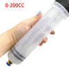 A hand is holding a clear manual fluid transfer syringe pump with markings, used for tasks like car oil extraction or brake b