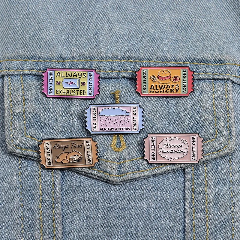 A set of vintage airline ticket enamel brooches featuring various humorous phrases like Always Exhausted and Always Hungry