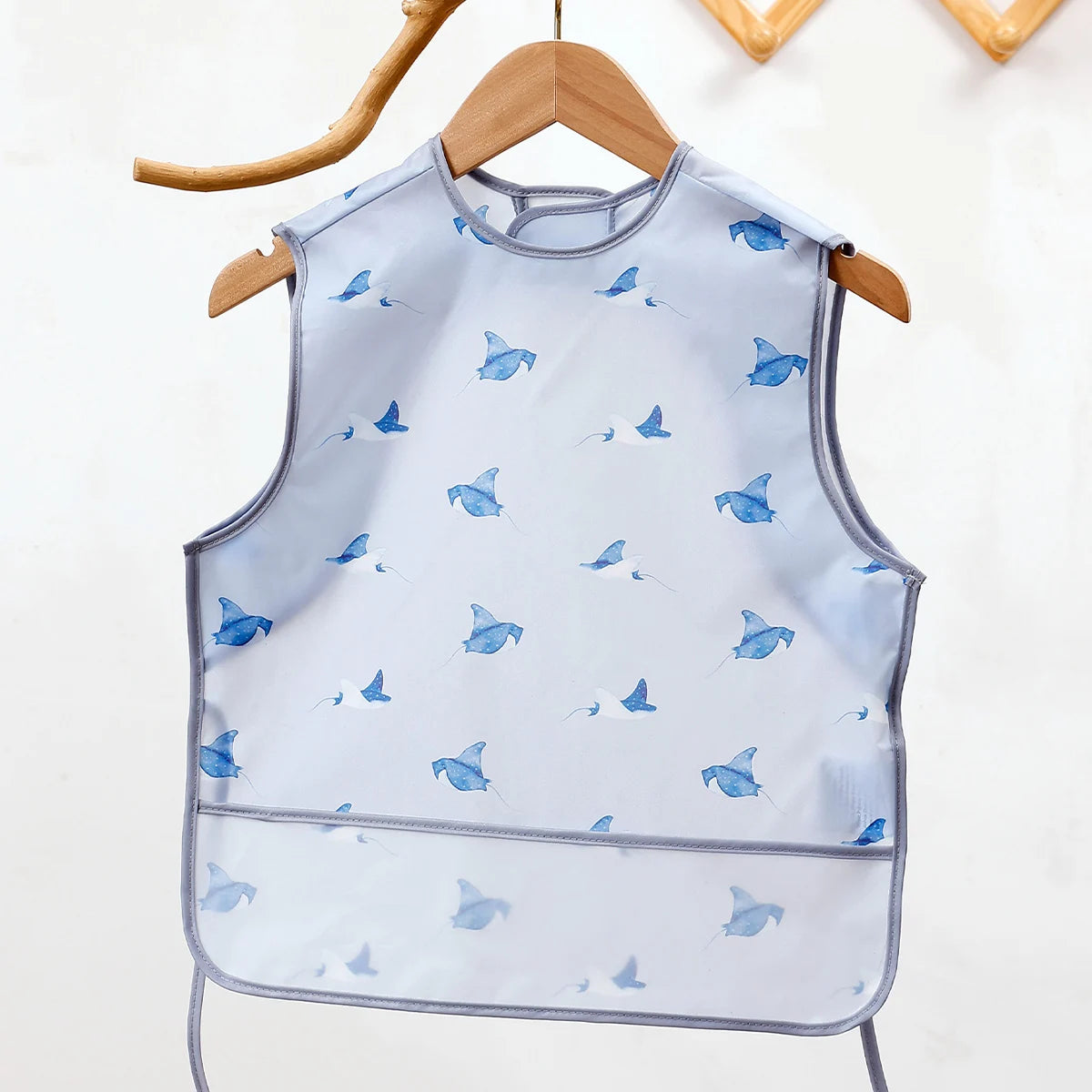 Light blue waterproof full-body baby feeding bib with a sleeveless design featuring small blue bird illustrations