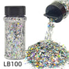 A glass jar of holographic chunky nail glitter mix with a shaker top next to a pile of the same glitter.