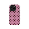A pink phone case with a dark polka dot pattern for an iPhone.