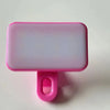 A pink rectangular clip-on LED selfie light with a pink mounting piece.
