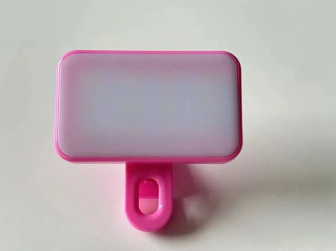 A pink rectangular clip-on LED selfie light with a pink mounting piece.