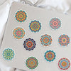 A collection of colorful mandala and graffiti stickers on a light gray surface.