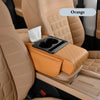 Orange car armrest cushion with cup holders and storage placed in a beige car interior.