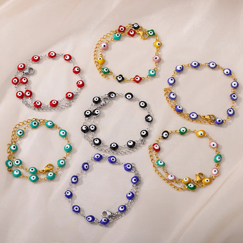 Eine Kollektion von Evil Eye Schutzarmbändern aus Edelstahl in farbenfrohen und goldenen Tönen.