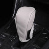 A light gray leather shift knob cover is shown resting on a black gear shift, highlighting its breathable texture.