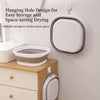 A white silicone washbasin is shown hanging on a wall, demonstrating a space-saving design for drying.