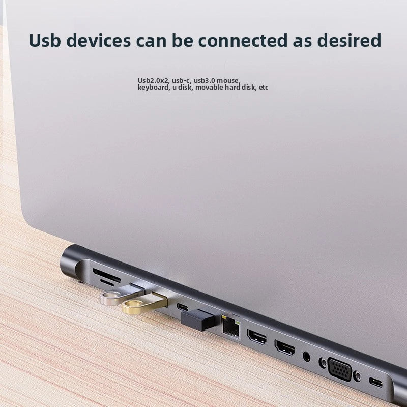 A close-up view of a laptop side showing a 12-in-1 USB-C docking station with various ports and connectors.