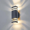 Modern up and down LED wall sconce with a dark gray finish casting light rays on a wall.