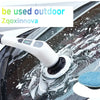 A white electric spin scrubber is cleaning water spots off a car's windshield with a blue scrubbing pad.