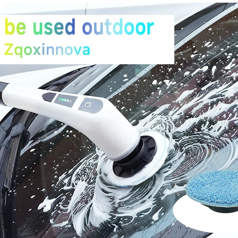 A white electric spin scrubber is cleaning water spots off a car's windshield with a blue scrubbing pad.