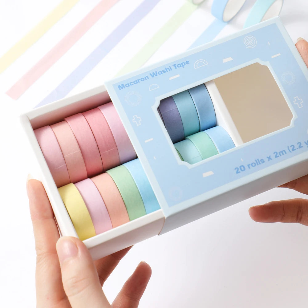 A box of 20 rolls of colorful macaroni washi tape in various pastel shades is held by a hand.