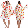Eine Frau modelliert einen gemütlichen, patchworkartigen, oversized Fleece-Hoodie mit Erdbeer-Print.