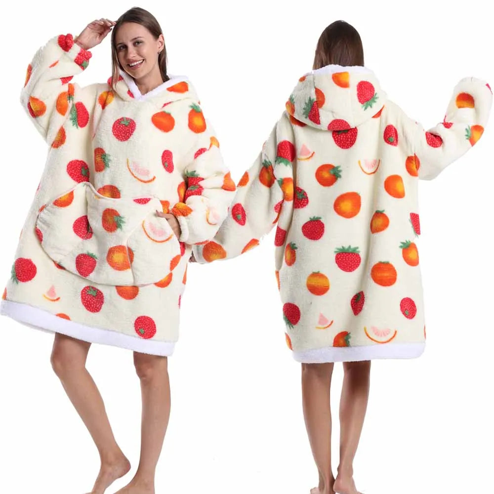Eine Frau modelliert einen gemütlichen, patchworkartigen, oversized Fleece-Hoodie mit Erdbeer-Print.