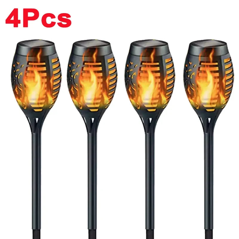 Four black solar flame torch lights with glowing orange flames