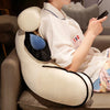A person is relaxing on a sofa while holding a dark electronic device, with an adorable cat and dog plush backrest cushion vi