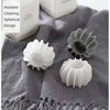 White and gray reusable laundry balls with spherical design shown on a textured cloth.