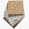 A stack of cotton fabric squares featuring various floral dot patterns in shades of brown, beige, and cream.