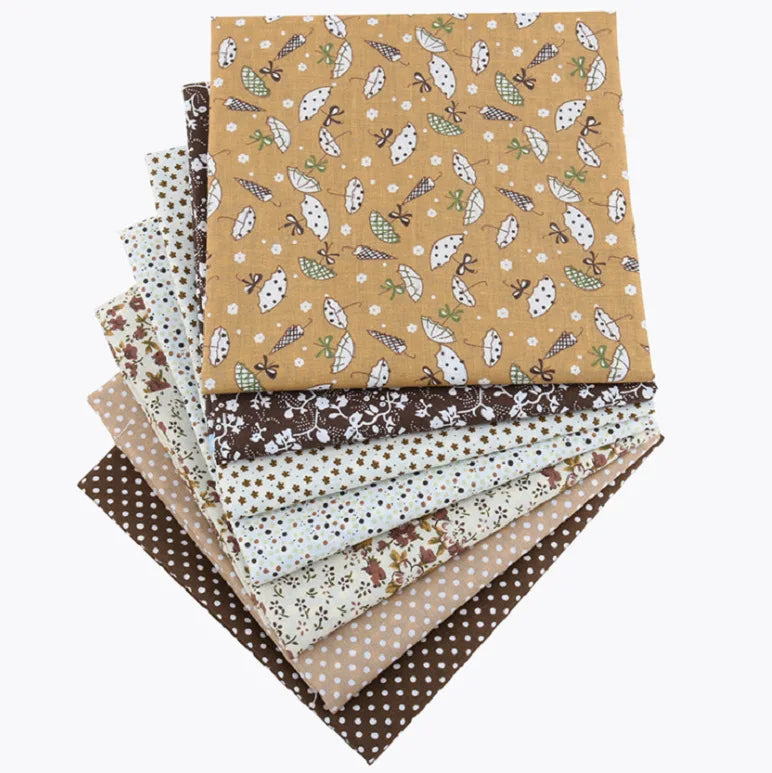 A stack of cotton fabric squares featuring various floral dot patterns in shades of brown, beige, and cream.