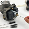 A carburetor cleaning kit showing a metal body, jet needles, and fine wire brushes.