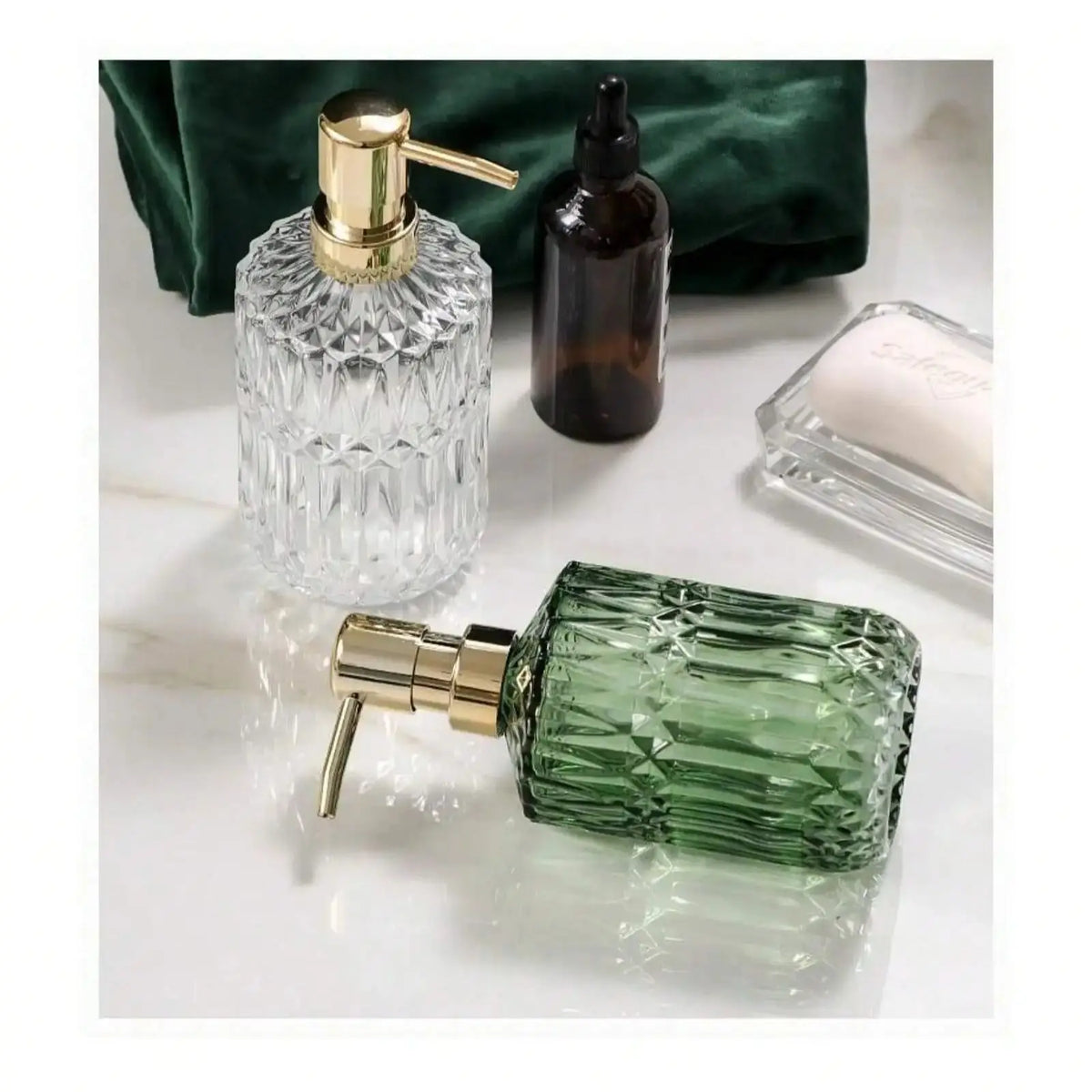 A green glass soap dispenser with a gold pump and a separate dark bottle are shown on a white marble surface.