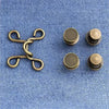 A set of brass metal jeans button snaps for waist adjustments, including a chain and individual round snaps.